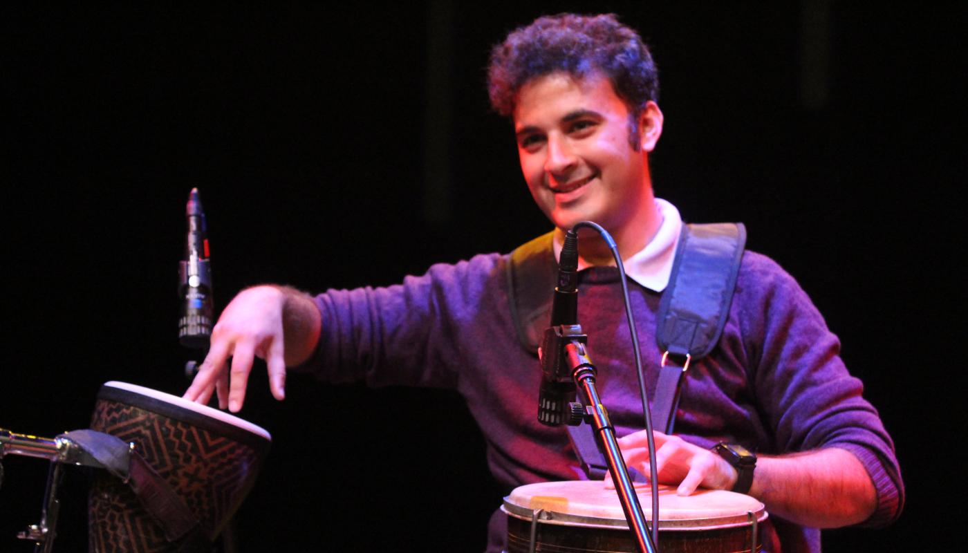 A man performs with two different hand drums