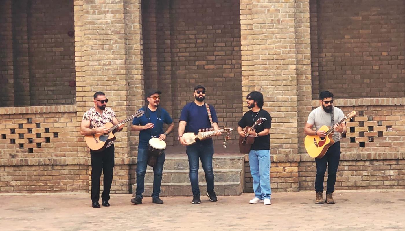 Khumariyaan by Isabel Soffer Five musicians with their instruments in a courtyard made of brick