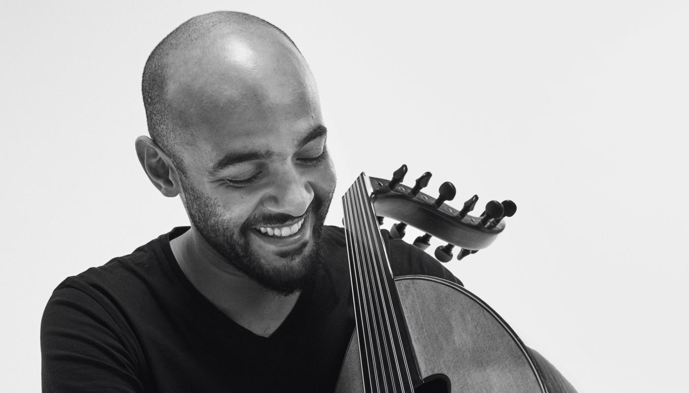 Momhamed Abozekry by Khaled Gohar A black and white portrait of a man in a black t-shirt holding an oud.