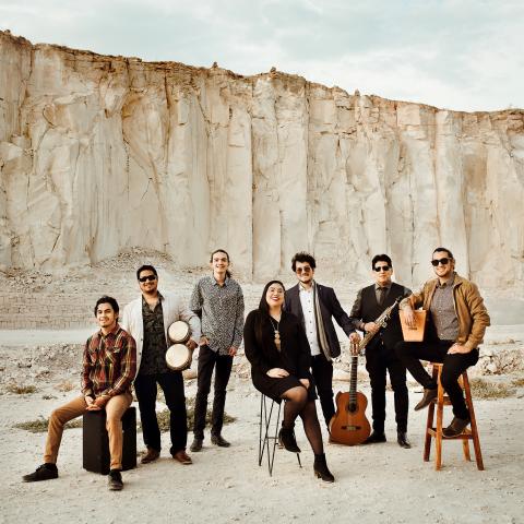 Lundú, by Marcos Herrera Photography Seven people standing together with various instruments in front of a large white cliff
