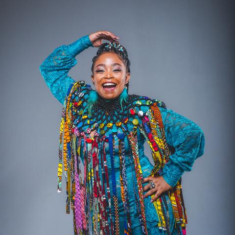 Nomfusi by Emp Cyclone A black woman poses for the camera wearing brightly colored clothes.